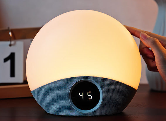 Round wake up light with digital display on a wooden surface