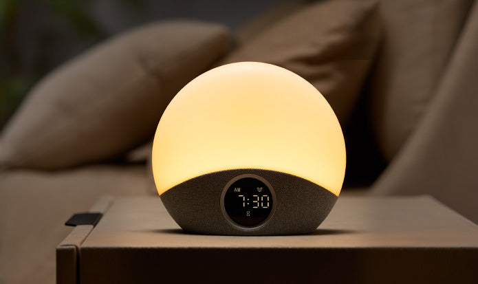 Round night light with digital clock on a surface, glowing softly.